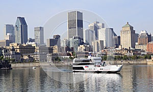 Montreal skyline and cruise boat reflected into Saint Lawrence River, Canada