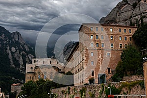 Mountain formations and abbey of Montserrat at a dark cloudy day photo