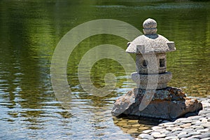 Monument at the edge of the dry rock garden and pond