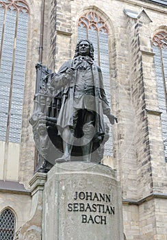 Monument of famous German composer Johann Sebastian Bach against St Thomas Church Thomaskirche in Leipzig, Germany