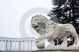 A monument of a lion with a ball