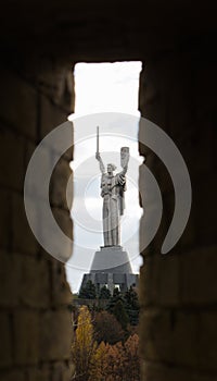 Monument of Motherland Mother trough the window of Kiev-Pechersk Lavra wall.