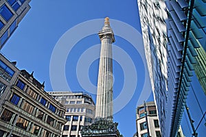 The Monument to the great fire in London surrounded by modern buildings in the financial district of the City of London