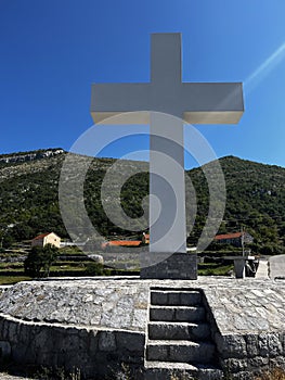 Monument to Jesus Christ and a large cross under the blue sky, above the Cievna canyon. Tourist route on the way to Grlo