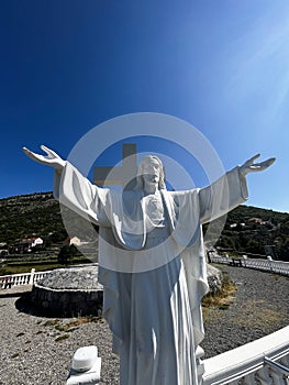 Monument to Jesus Christ and a large cross under the blue sky, above the Cievna canyon. Tourist route on the way to Grlo
