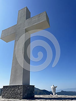 Monument to Jesus Christ and a large cross under the blue sky, above the Cievna canyon. Tourist route on the way to Grlo