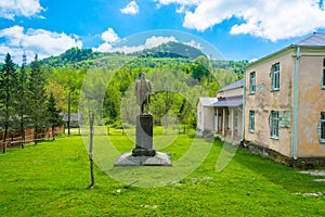 The monument to Lenin on a background of green mountains.