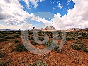 Monument Valley landscape view, Utah, desert vegetation, blue cloudy sky