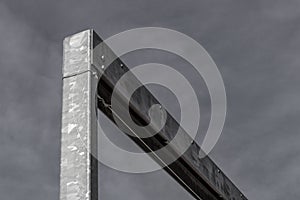 Monumental angled galvanized steel beams against a dark gray sky, copy space