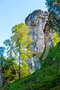 Monumental sandstone rock formation in the miidle of spring forest of Bohemian Paradise, Czech: Cesky raj, Czech