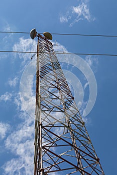 Monumental view of a telecommunications tower structure, microwave antennae, blue sky
