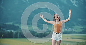 Mood of cinematography, gentle tones, alpine meadows and Austrian mountains. Cute Asian young woman with field flowers