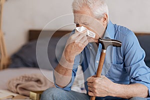 Moody aged man blowing his nose