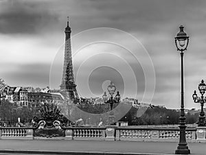 Moody cityscape with Pont Alexandre III bridge, Seine river and Eiffel Tower in Paris, France in black and white