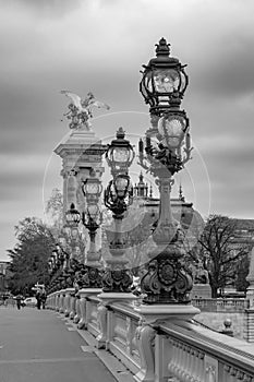 Moody cityscape with Pont Alexandre III bridge and Seine river in Paris, France in black and white