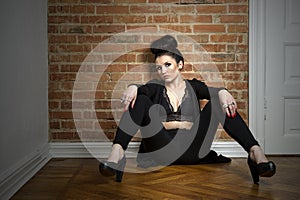 Moody elegant woman sitting on a parquet floor