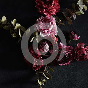 Moody floral concept - flower on dark textured background, square composition