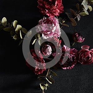 Moody floral concept - flower on dark textured background, square composition photo