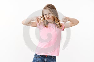 Moody picky ignorant blond little girl kid, show thumbs down frowning, grimacing aversion and disappointment, show photo