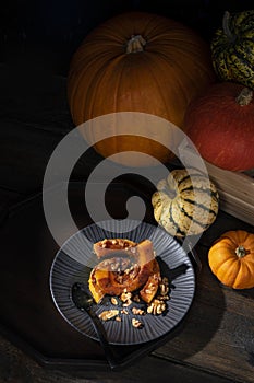 Moody pictorial still-life of roasted butternut squash pumpkin dusted with cinnamon, walnuts and honey