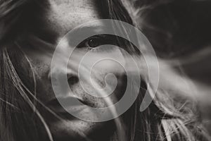 Moody portrait of young woman and wind through hair