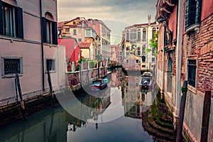 Moody spring picture of Vennice with famous water canal and colorful houses.