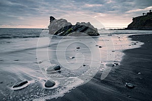 Moody sunset in black sand beach of Praia Formosa