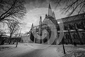 A moody wide angle black and white photograph of the Nidaros Cathedral in Norway