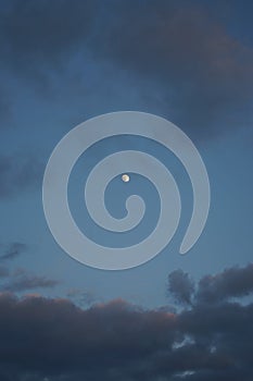 The moon on the background of the cloudy sky in the evening. Berlin, Germany