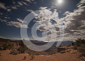 Moon beams light the rim of Smith`s Mesa as lightning strikes east of Zion National park.