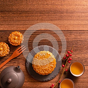 Moon cake Mooncake table setting - Chinese traditional pastry with tea cups on wooden background, Mid-Autumn Festival concept, top