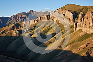 moon casting long shadows over rugged mountain terrain