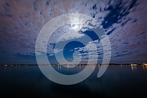 The moon and clouds moving over Lake Ontario, at the Harbourfront in Toronto, Ontario.