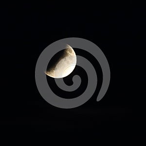 The moon in a dark sky half eclipse