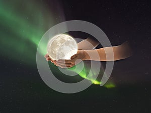 Moon in hand  on front blue starry  sky Aurora bolearis  natire background