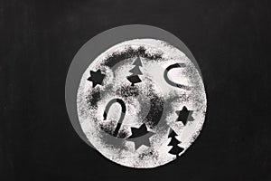 Moon with holiday figures of sugar on chalkboard