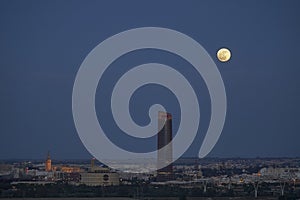 The moon illuminates the sky of seville, skyline of seville, Giralda and Pelli Tower