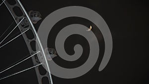 Moon at the night sky with Ferries wheel in the foreground