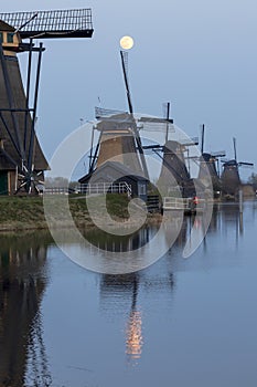 Moon over the historic windmills of Kinderdijk in Holland