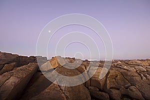 Moon over ocean and rocks