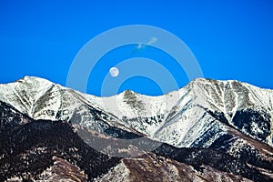 Moon Over Snowcapped Mountain