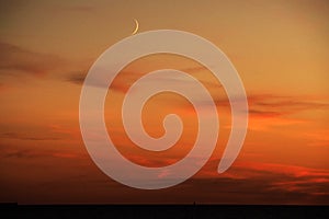 Moon and red clouds after sunset