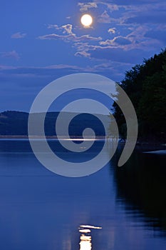 Moon reflecting in lake at twilight in spring season