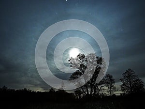 Moon rise halo night sky stars and clouds observing autumn landscape