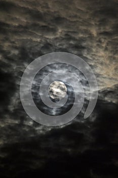 Moon rising in the clouds over lake Ontario