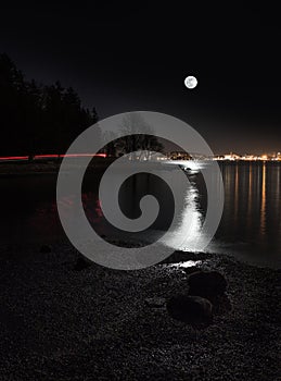 Moon rising over the city viewed from Vancouver`s Stanley Park.