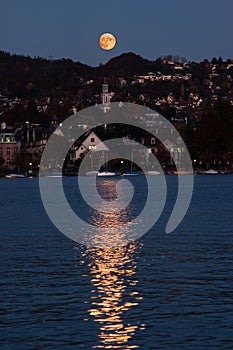 Moon rising over the hills on Zurich Switzerland lakeside point of view late evening