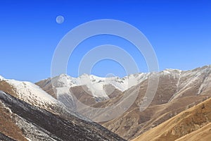 Moon rising over Mountain Tibetan Himalayan landscape in SiChuan province, China