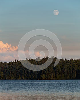 Moon Rising Over Pink Clouds Green Forest and Lake Sunset