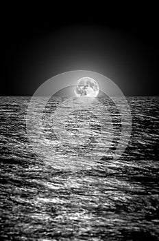 Moon rising over the sea at night. long exposure